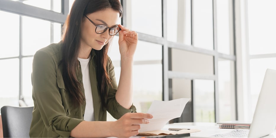 Woman wearing glasses looking at papers