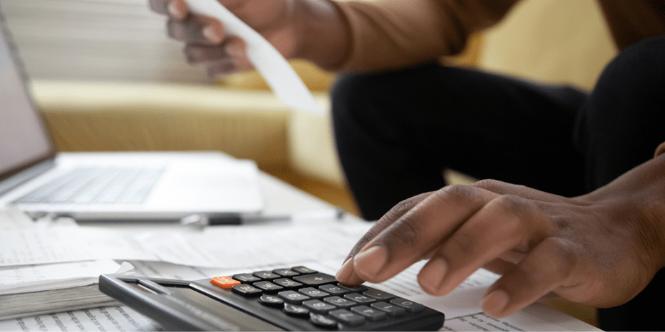 Man's hand typing on a calculator