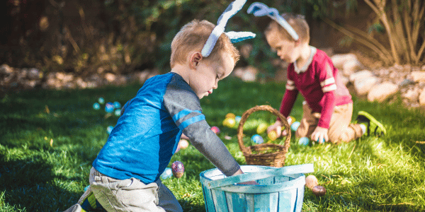 two young boys collecting Easter eggs for their Easter basket at an Easter egg hunt outside