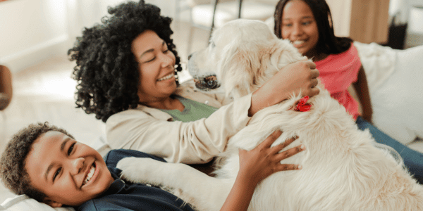 mother and children playing with new dog on couch