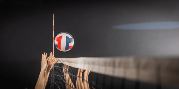 female hands blocking volleyball at volleyball net in volleyball game