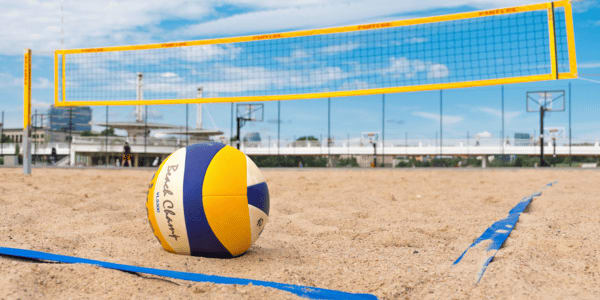 volleyball sitting in sand on beach volleyball court