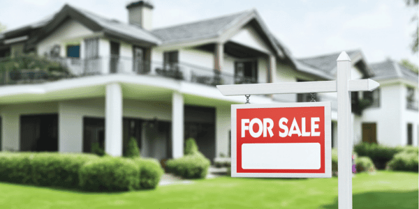 Real Estate Sign in Front of a House with a Garden for Sale 