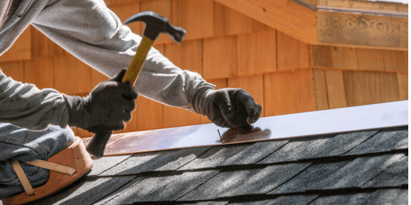 installing new roof with hammer