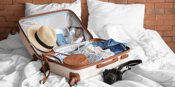 packed suitcase sitting on bed for beach vacation