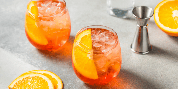 two aperol spritzes in stemless wine glasses