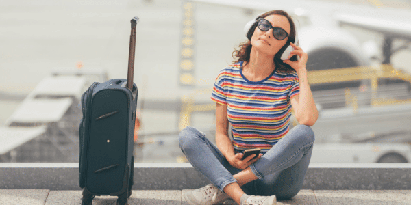 woman sitting on ground at airport listening to music