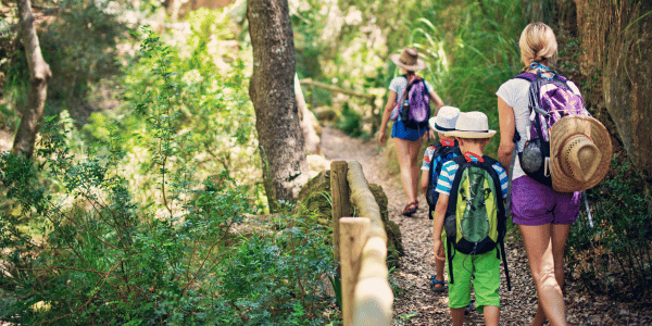 family of four hiking on trail in nature