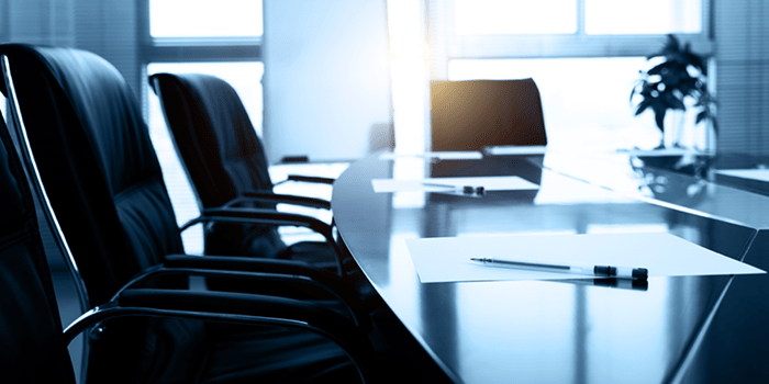 Empty boardroom for an HOA with papers and pens laid out on table.