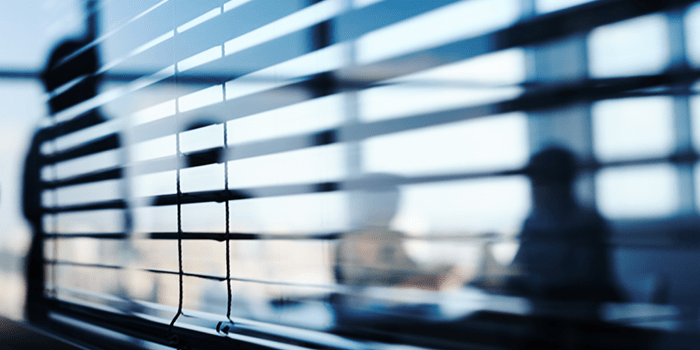 silhouette of board room meeting behind blinds