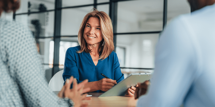 Financial advisor holds clipboard and pen in client meeting