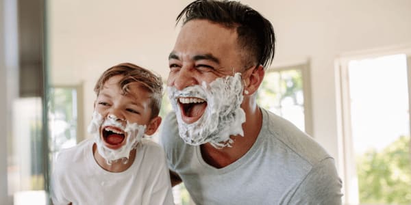 father and son looking in mirror with shaving cream telling dad jokes