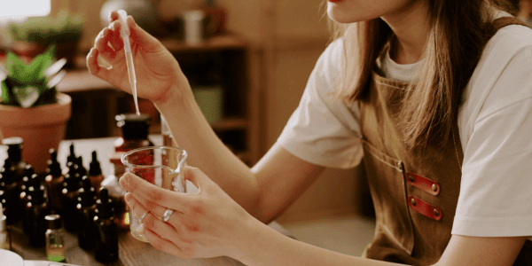 woman making DIY reed diffuser to make house smell good