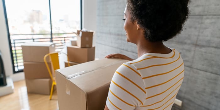 Woman holding moving box in packed up house