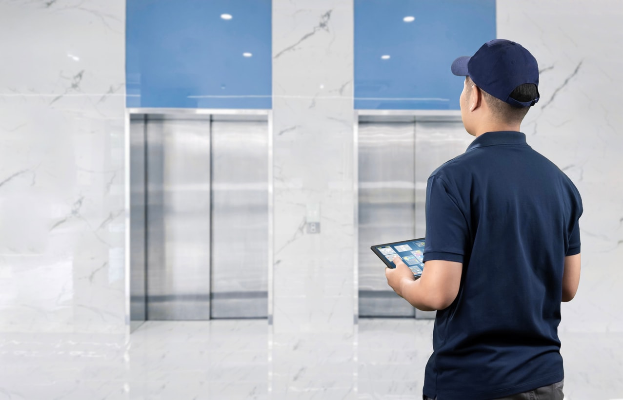 man conducting elevator safety inspection in apartment building