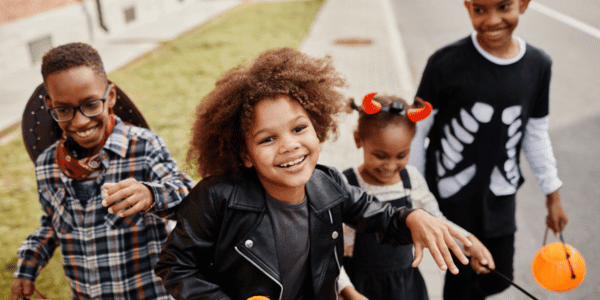 four children in Halloween costumes at trunk or treat event
