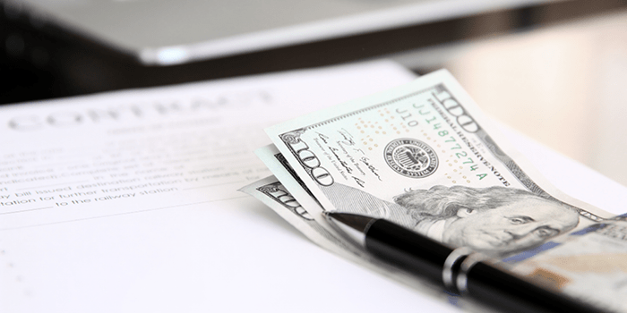 3 $100 bills and a pen sitting on top of a contract