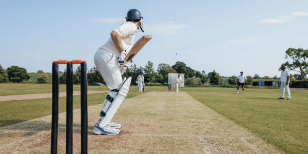 cricket player on field getting ready to bat ball