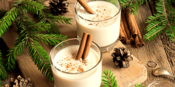 two cups of eggnog with cinnamon sticks