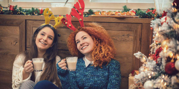 friends celebrating Christmas with mugs of eggnog