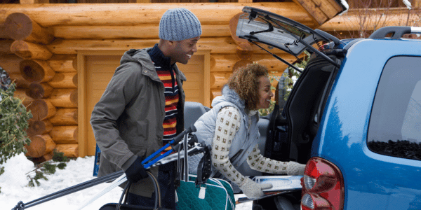couple loading car up with skis for ski trip