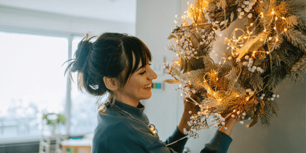 young woman taking down Christmas wreath