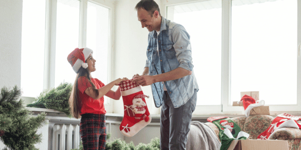 father and daughter taking down Christmas stockings