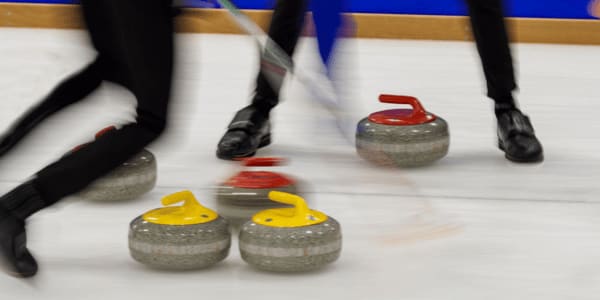 sweepers playing curling on ice