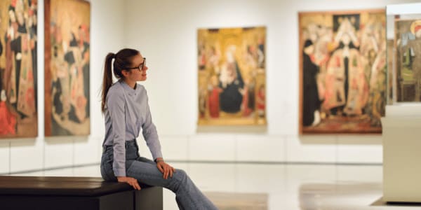 thoughtful young woman sitting in art museum