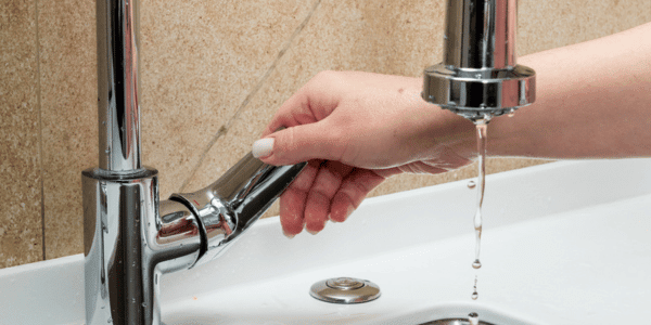 woman running faucet to prevent frozen pipes
