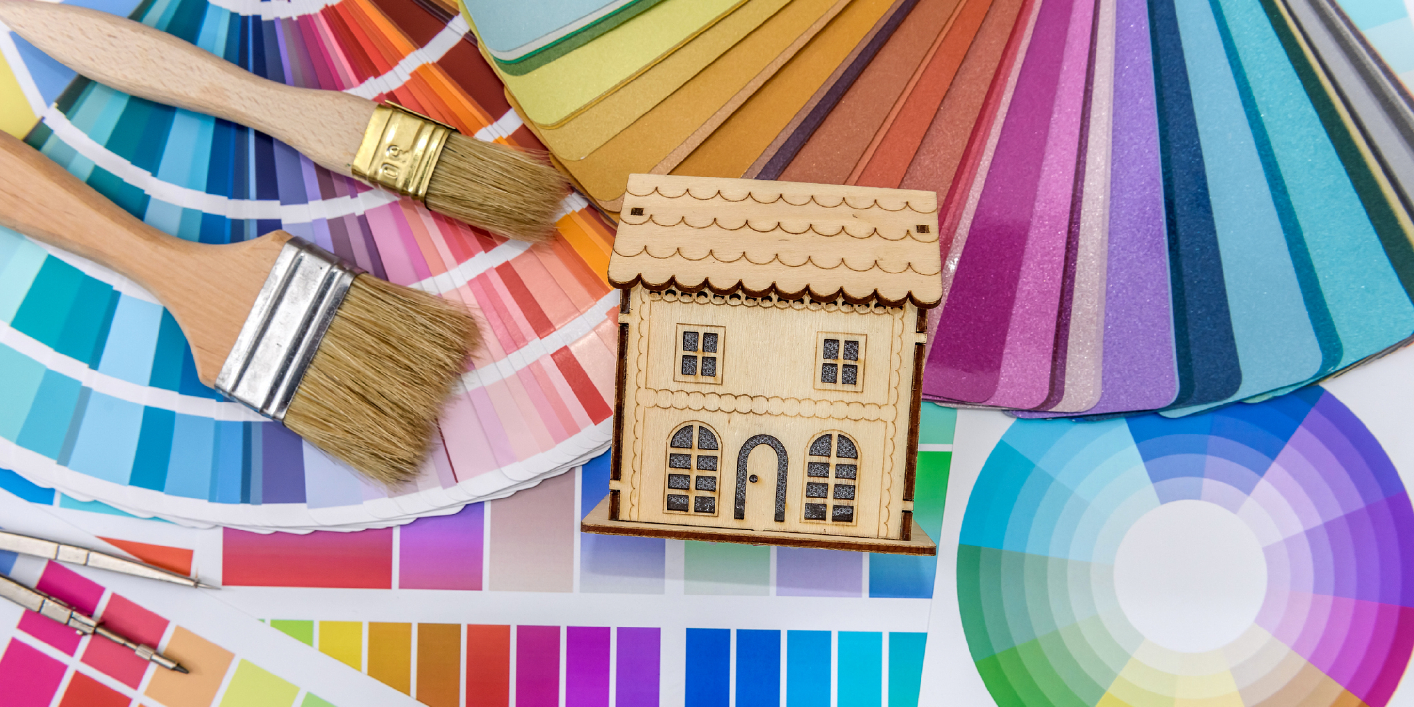 Close up of a color swatch with a wooden house model laid on top of it.