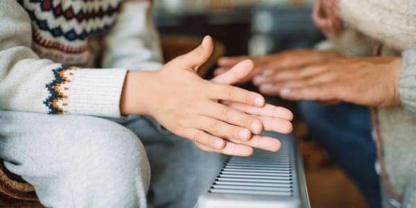 family warming hands over portable space heater
