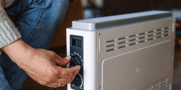 man turning on portable space heater