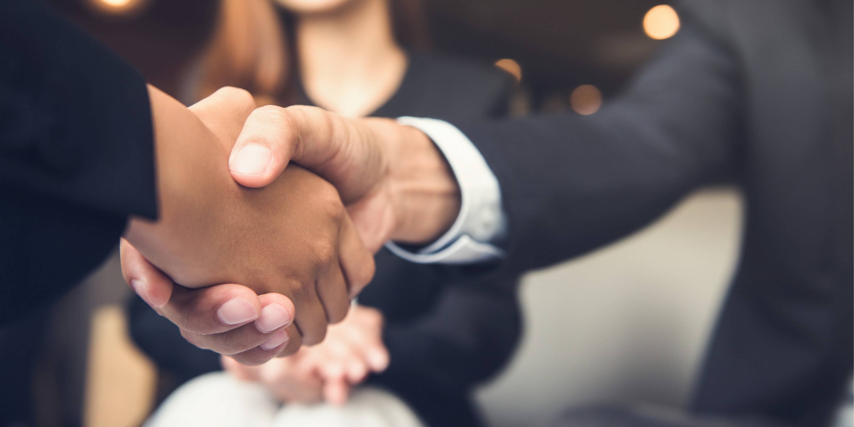Close-up of businessmen shaking hands after a meeting.