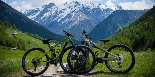 two bikes stationed in front of a mountain range on a biking trail