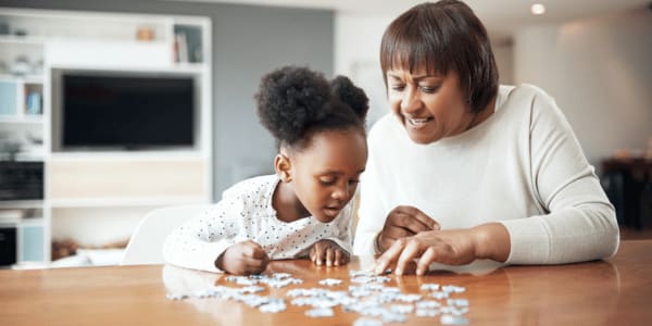 mother and daughter doing a puzzle on rainy day
