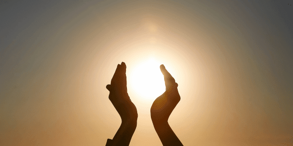 person holding sun between hands during summer solstice