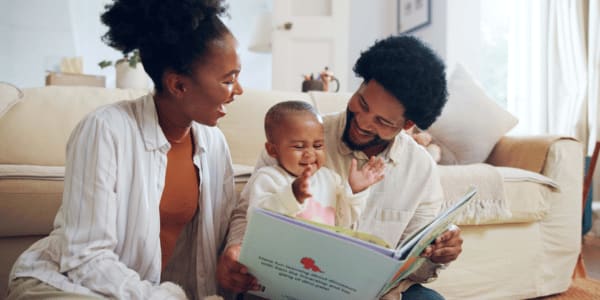 two parents reading to young child