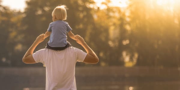 man carrying son on shoulders for Father's Day