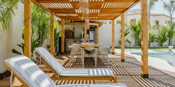 modern pool with wood outdoor lounge chairs and dining table.