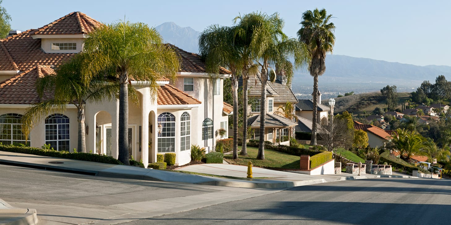 Upscale home in a southern California neighborhood with hills and mountains in the background.