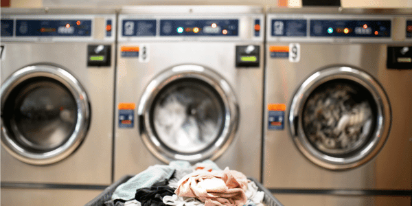 college dorm laundry machines with basket of dirty laundry