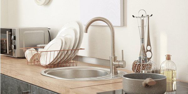 kitchen sink area with plates and a garbage disposal