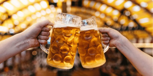 two people cheers-ing with beer mugs at Oktoberfest
