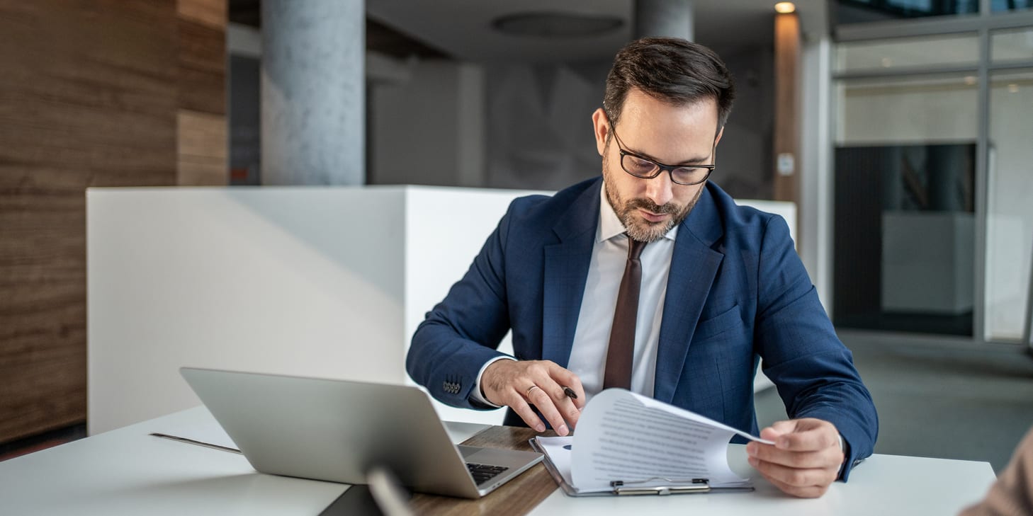 Businessman reviewing legal documents in a modern office setting