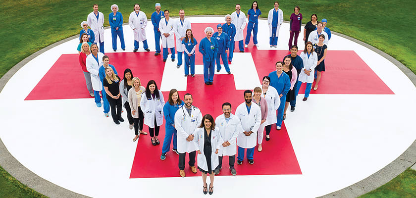 Clinicians and caregivers from Providence Heart Institute gather at the helipad at Providence St. Vincent Medical Center.