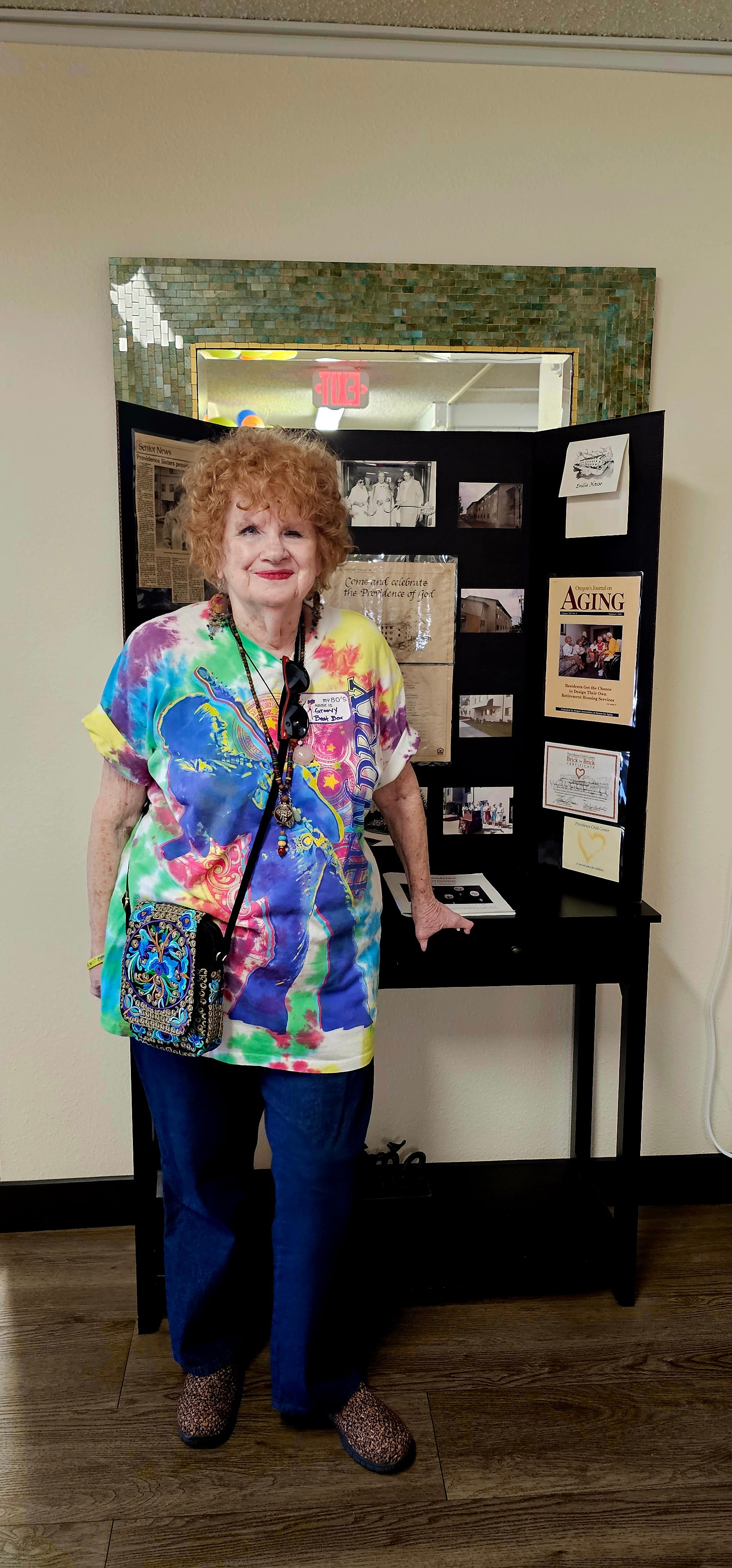 Resident Mary Howard poses with a display of ephemera representing 40 years of Emilie House history.