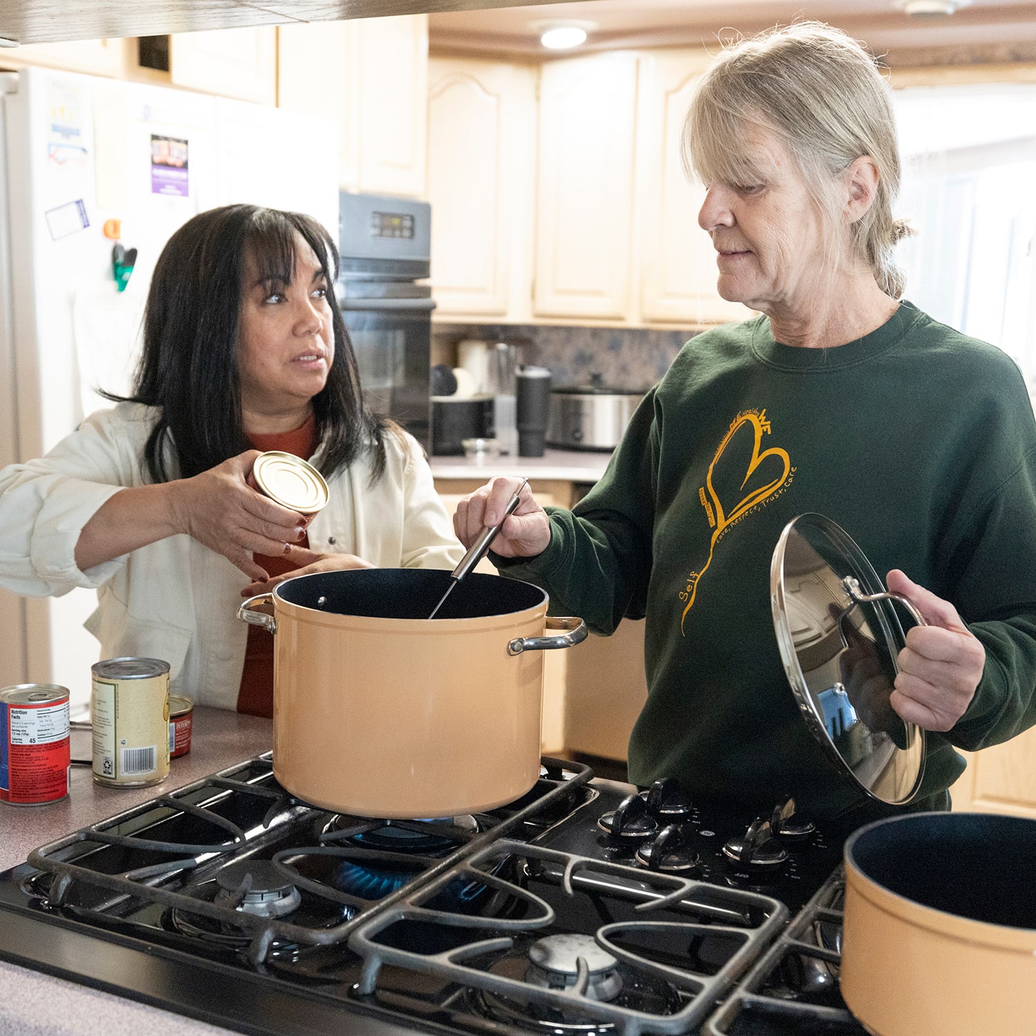 Rowena Palomar and Nanci Hill preparing meals in the shelter kitchen.
