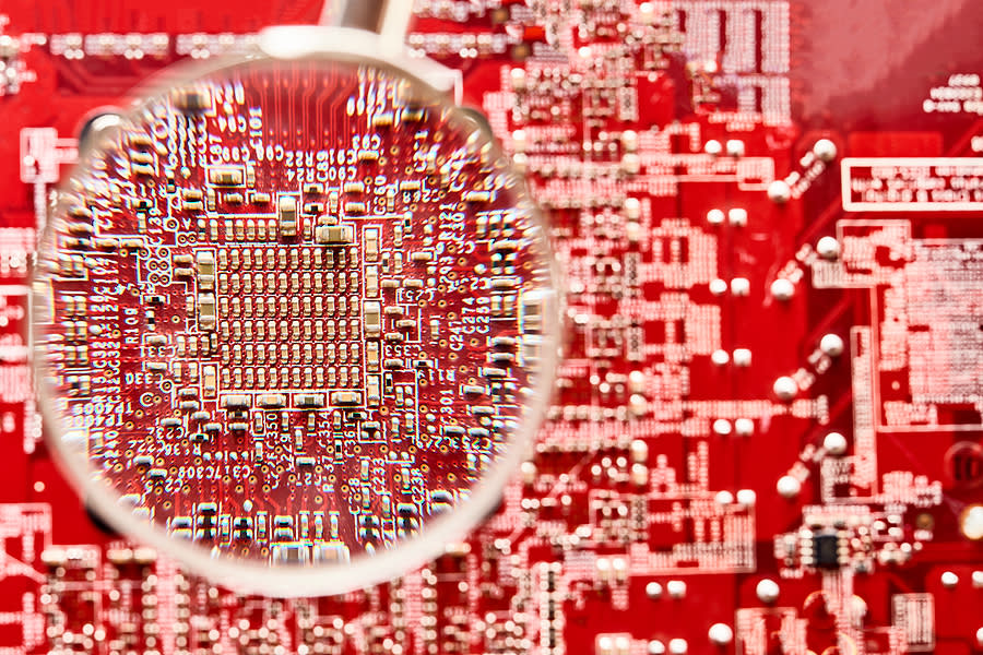 Magnified view of components and their connections on a red PCB.