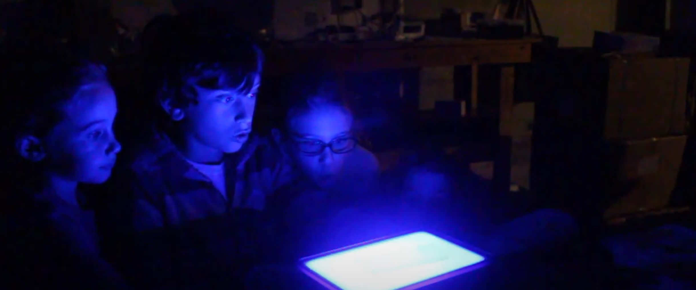 Students looking at glowing Gel Electrophoresis Activity